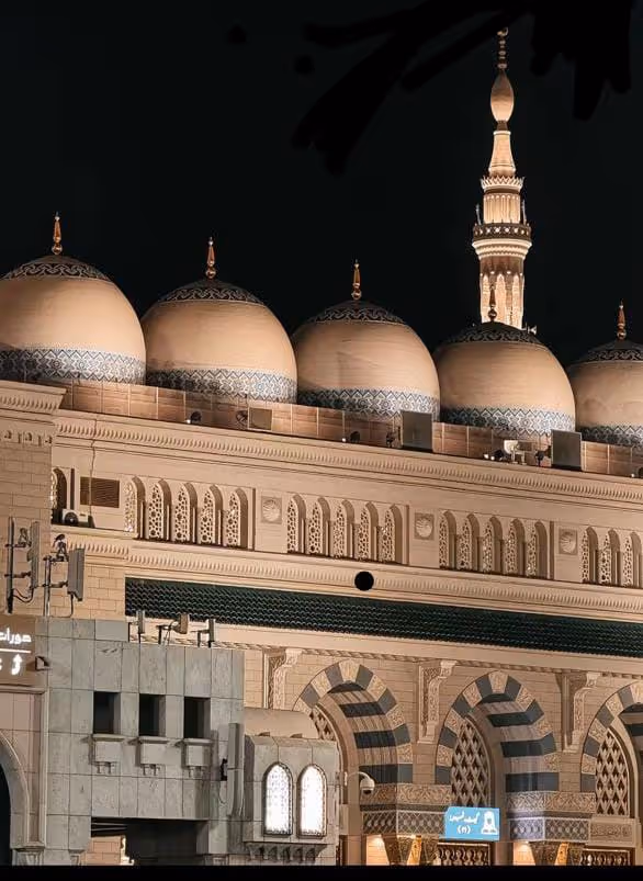 Masjid Al-Nabawi at night with beautiful domes and minarets